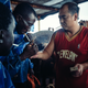 Chief mate Wang of a boat in the Atlantic naval territory of Guinea-Bissau passes cigarettes to local sailors.